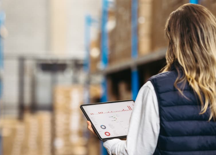Third-party tools click-through with image of a woman wearing a blue vest, holding a tablet looking onto an aisle filled with boxes in a warehouse