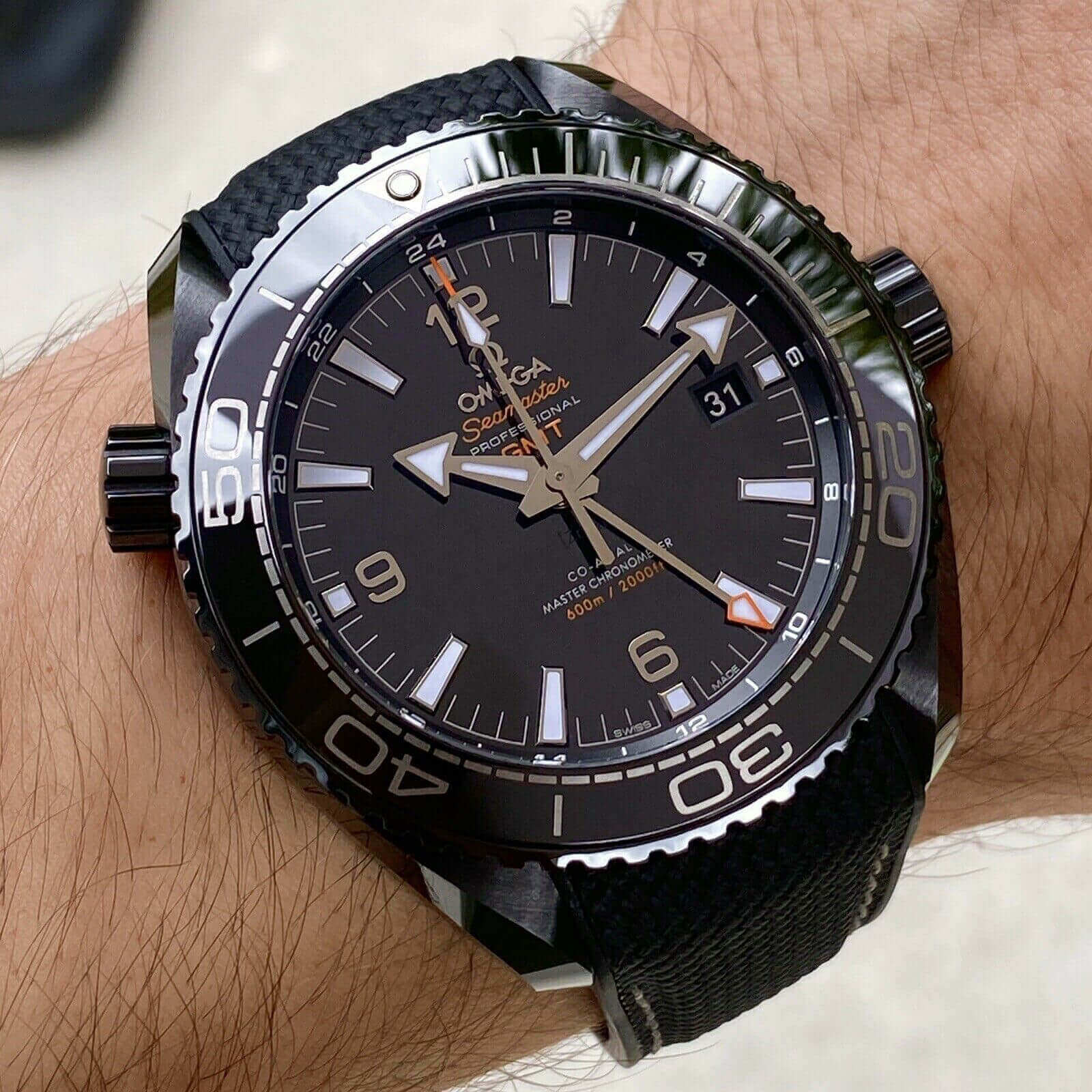 A black  Omega Seamaster Planet Ocean watch with a black face.