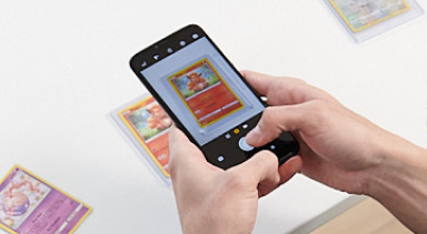A person takes a picture of a trading card using their smartphone.