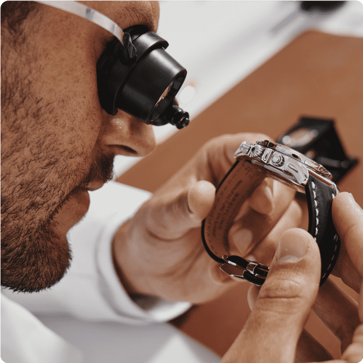 An authenticator inspects a watch.