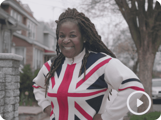 Video thumbnail of Sandra Gustard, smiling, wearing long locs and a Union Jack sweater. 