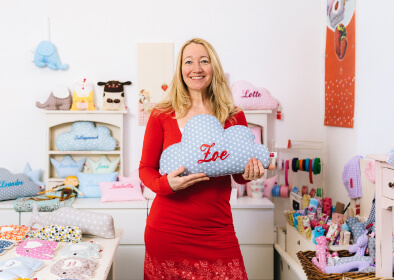 Die Besitzerin von „La fraise rouge“ in ihrem Laden mit einem „Zoe“-Namenskissen in der Hand