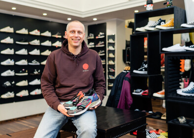 Der Besitzer von „Solekitchen“ in seinem Laden mit einem Paar Sneaker in der Hand