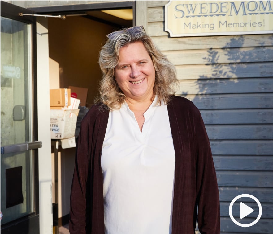 Seller Cami Nyquist smiling at the camera in front of the Swedemom store.