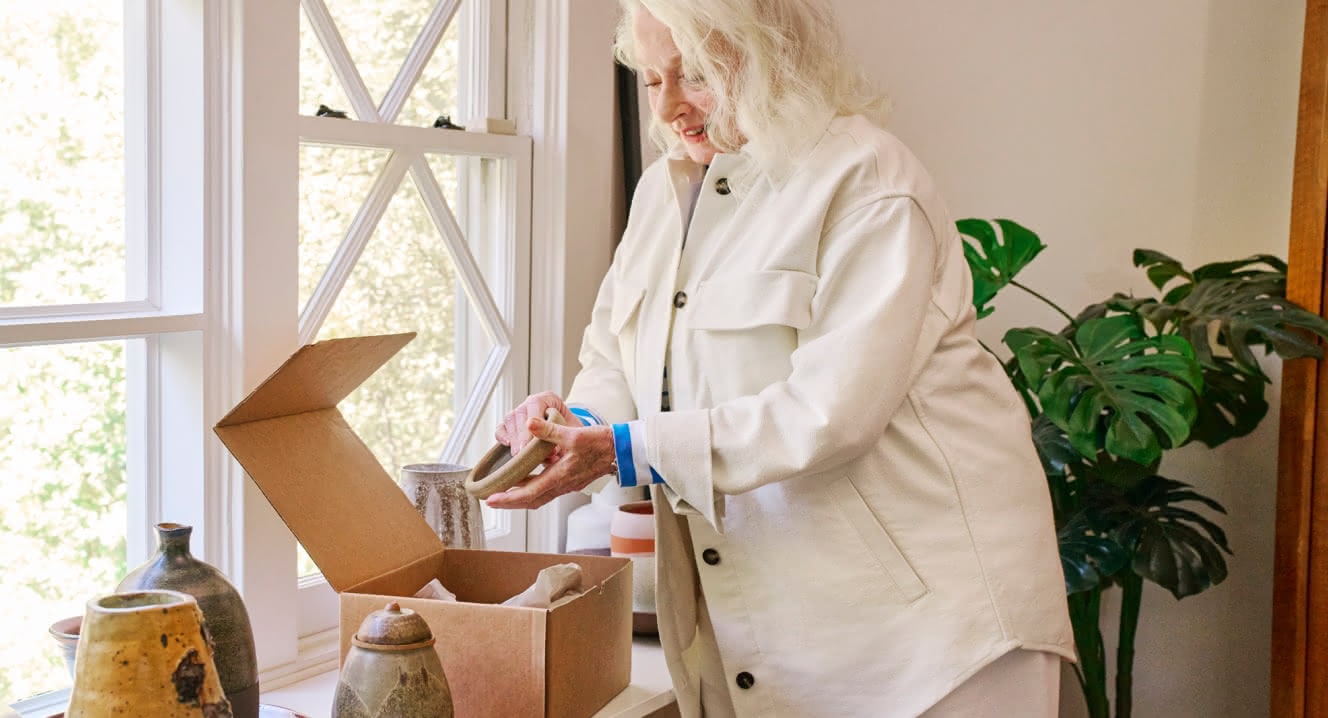 A woman removing an item from a box linking to eBay Money Back Guarantee