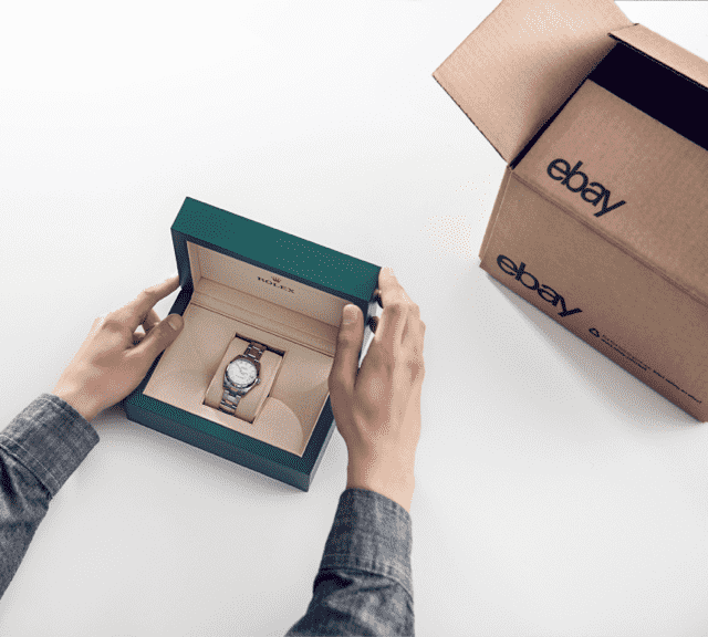 Person unboxing a Rolex watch from an eBay package.