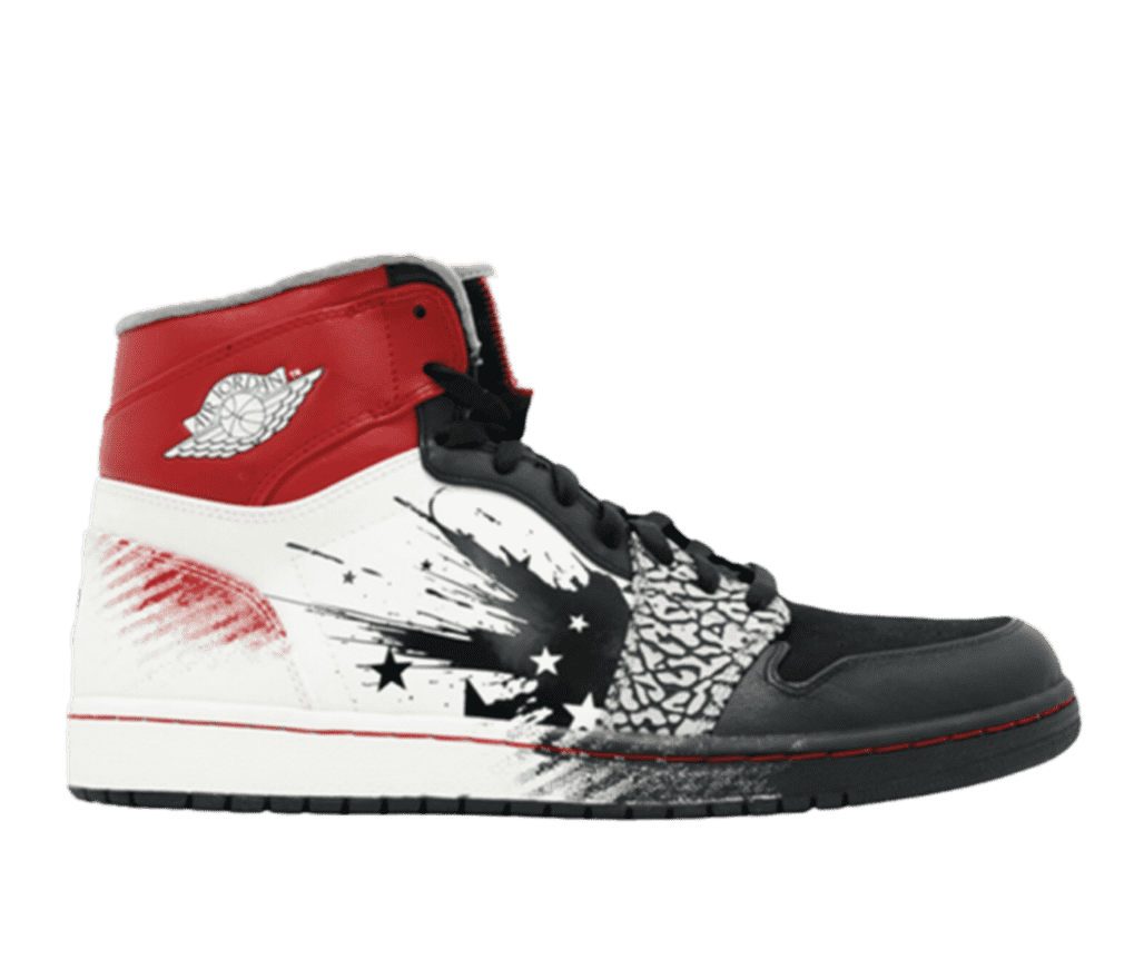 Side view of an Air Jordan sneaker. The toe is black and transitions to white towards the back in an explosion-like design. The base of the heel has a splash of red across the white and the top of the heel is all red with the Air Jordan symbol in white.