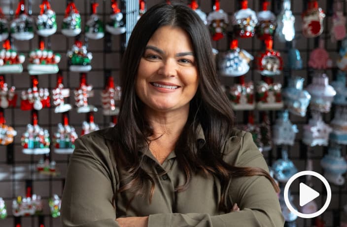 Video thumbnail of Tracey Lewis smiling into the camera as she stands infront of a wall full of Christmas ornaments.