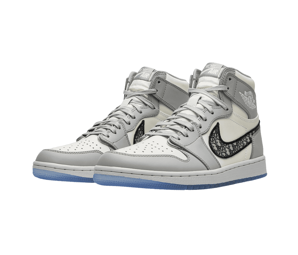 A pair Dior x AJ1 “High Dior” sneakers in white and light gray, with embroidered Dior markings on the Swooshes, and light blue semi-translucent outsoles.
