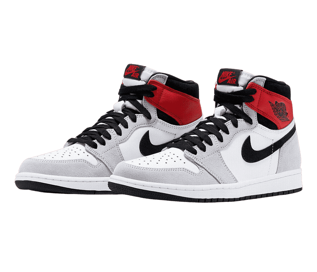 A pair of AJ1 “Smoke Gray” sneakers in white and light gray suede, black laces, Swooshes, and outsoles, and red details at the tongues and collars.