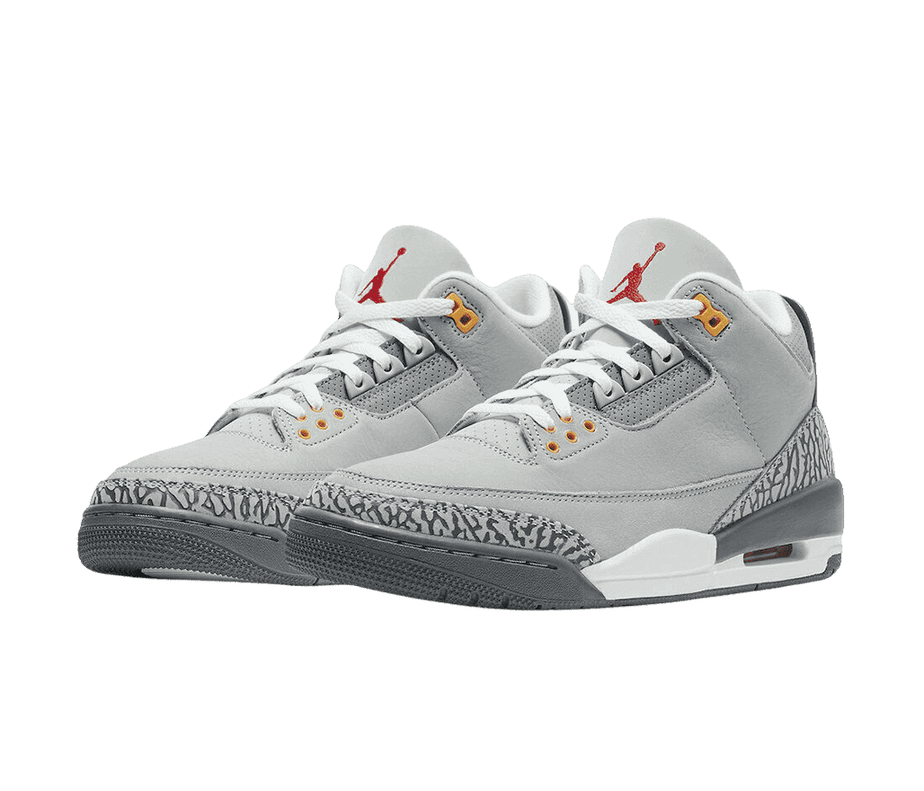 A gray suede pair of AJ3 “Cool Grey” sneakers with elephant print heels and tips, gray and white soles, and orange eyelets. 