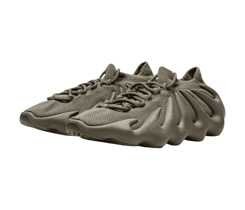 A pair of Adidas Yeezy 450 “Cinder” sneakers in a dark tan monochromatic colorway with a cuffed collar and wavy rubber soles.