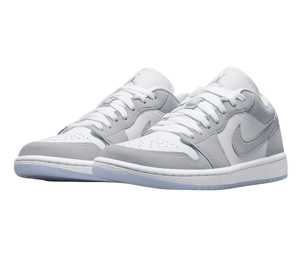 A white pair of AJ1 Low “Wolf Grey” sneakers with light gray overlays and light blue outsoles.