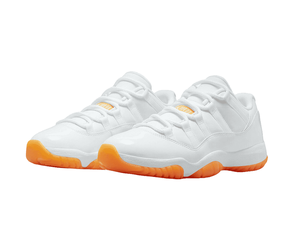 An all-white pair of AJ11 Low “Citrus” sneakers with bright orange outsoles.