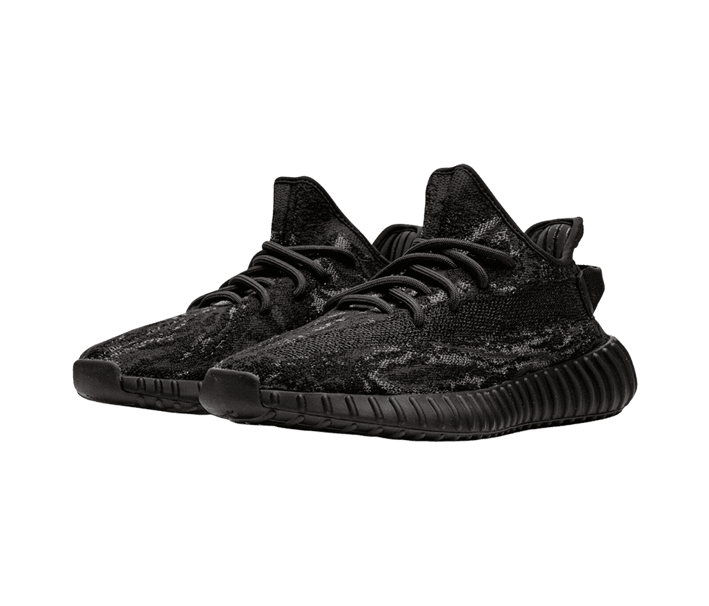 A pair of YEEZY V2 Black sneakers with a textured upper mesh and black, ribbed, boosted soles. 