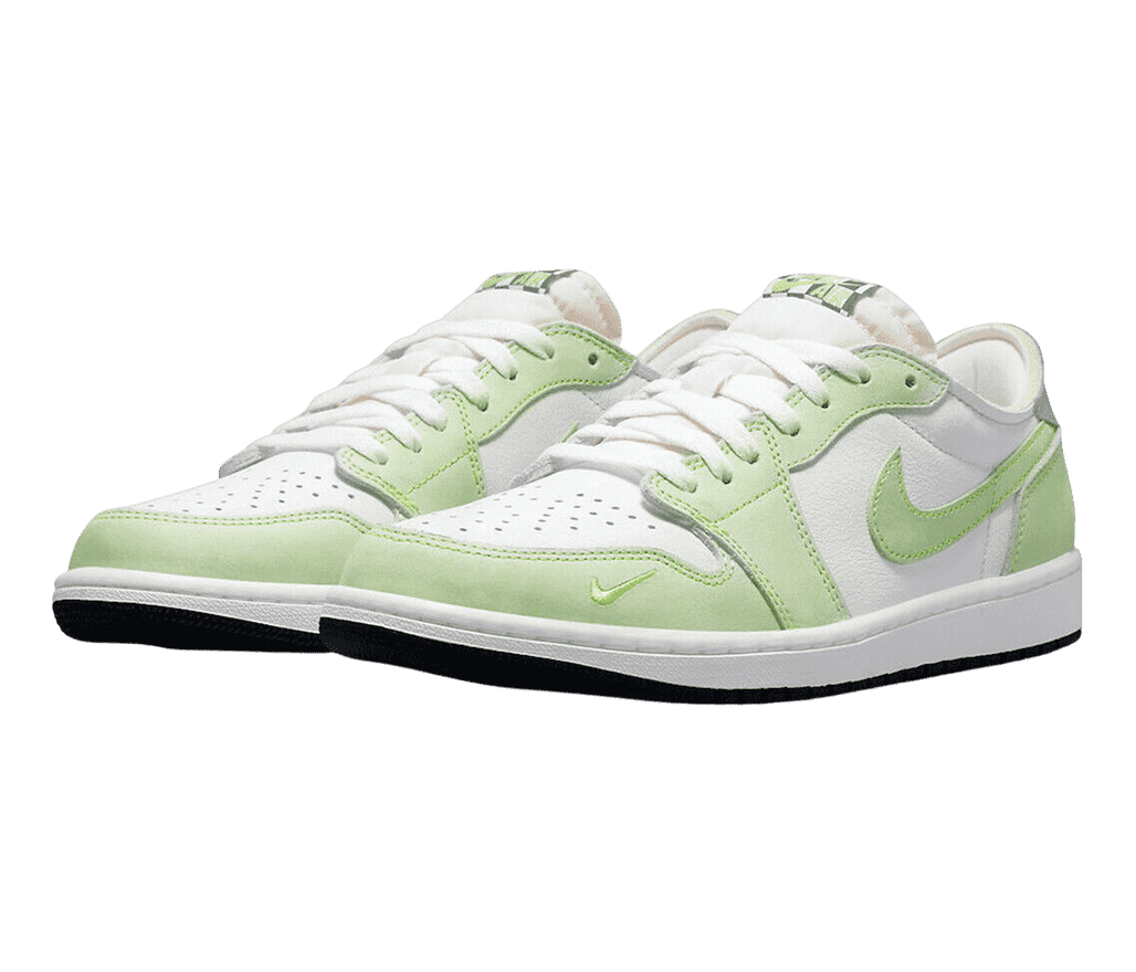 A white pair of AJ1 Low sneakers with lime suede overlays, black outsoles, and a small embroidered Swoosh on the outer toe.