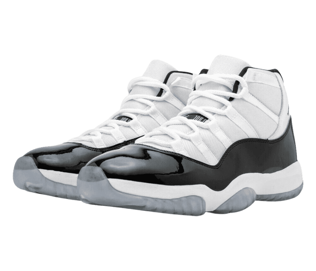 A white pair of AJ11 High sneakers with black patent leather overlays and blue-gray translucent outsoles.
