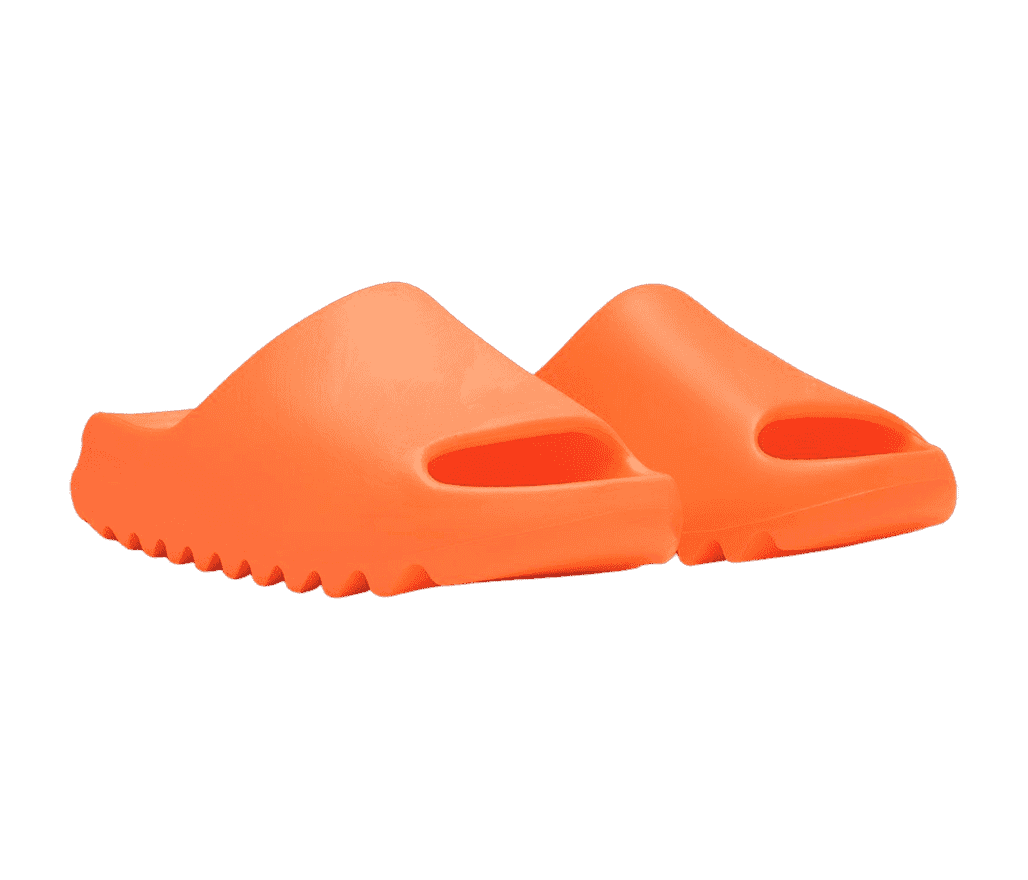 A pair of YEEZY slides in orange made in a one-piece mold made entirely from EVA foam.