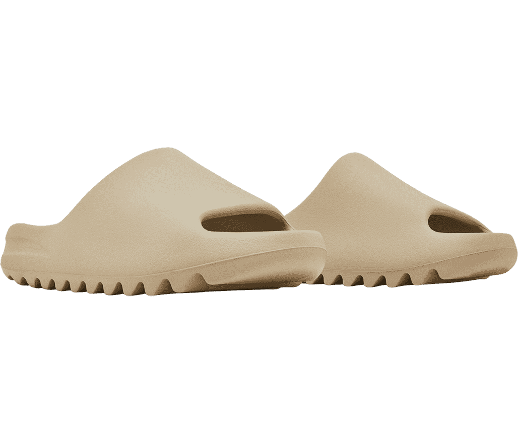 A pair of YEEZY slides in light beige made in a one-piece mold made entirely from EVA foam.