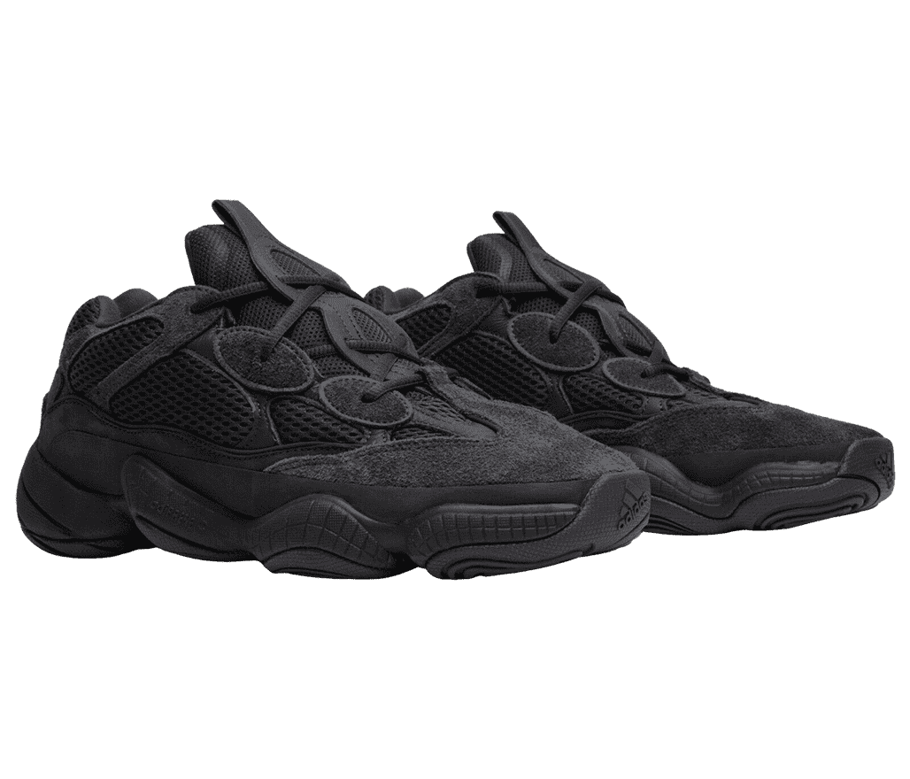 A pair of YEEZY '500 Utility Black' sneakers are
                      all-black with extra round eyelets and a braided design along the tongue. 
