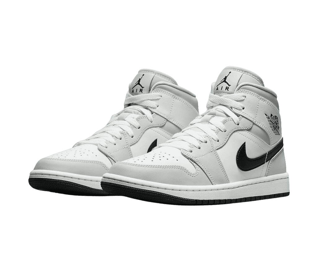 A white pair of AJ1 sneakers with light gray overlays and black outsoles and Swooshes.
