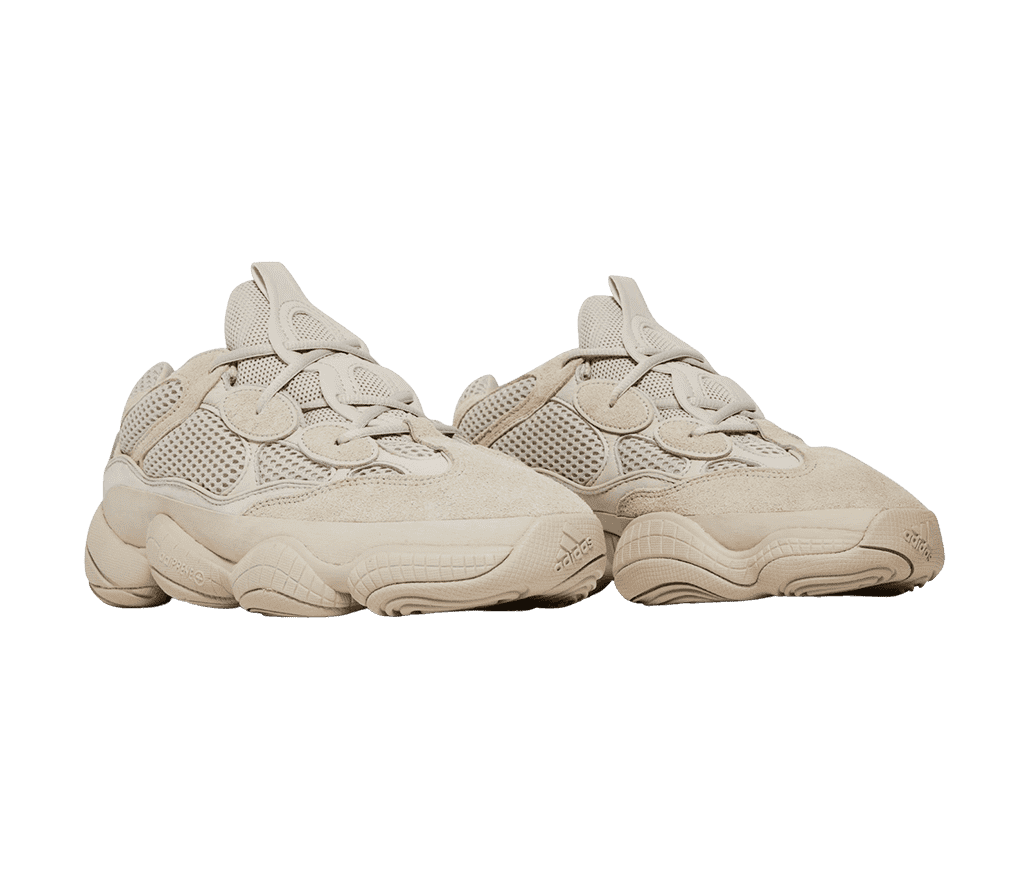 A pair of YEEZY '500' sneakers are all-beige with
                      extra round eyelets and a braided design along the tongue. 