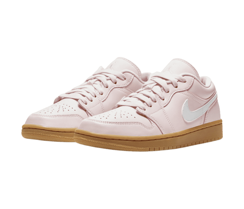 A light pink pair of AJ1 Low sneakers with dark gum soles and white Swooshes.