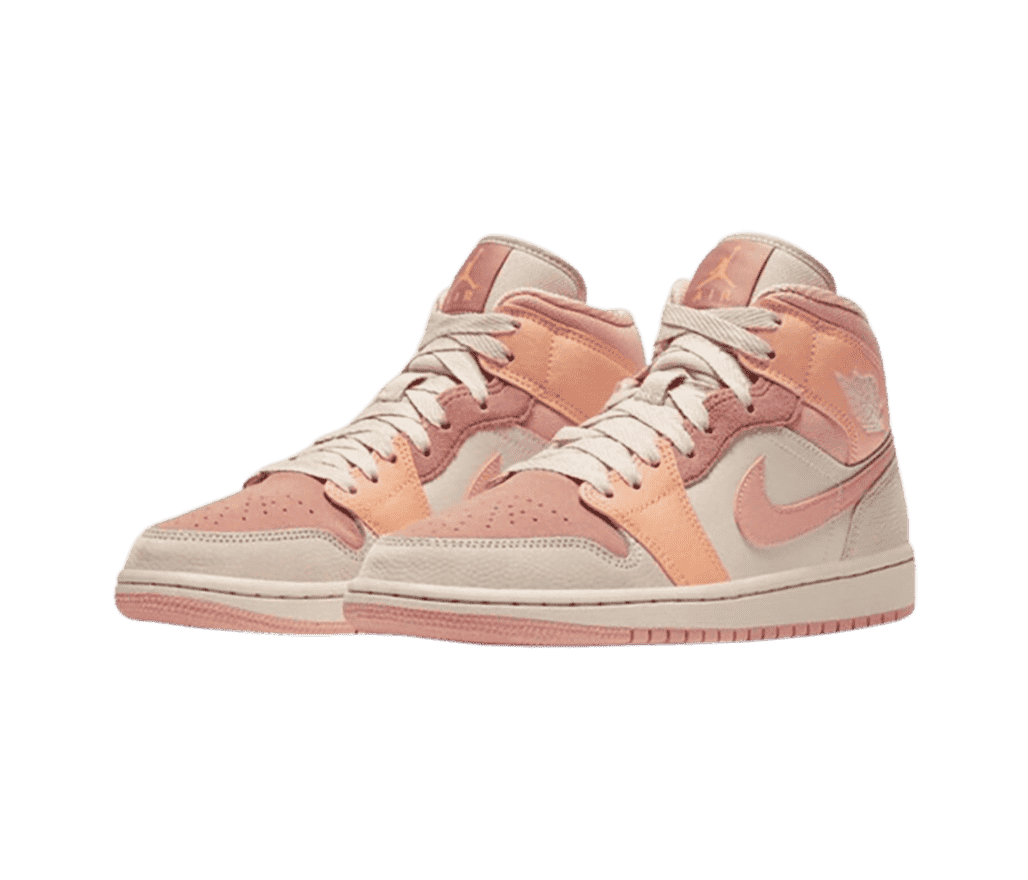 A pair of AJ1 Mid sneakers in salmon, peach, and off-white suede and leather.