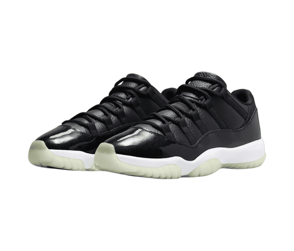 A pair of black AJ11 “Concord” sneakers with patent leather overlays and off-white translucent outsoles.