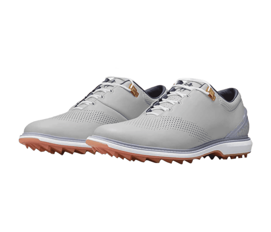 A gray suede pair of Jordan ADG 4 golf shoes with perforated sections, gold lace locks, and spiked gum soles.
