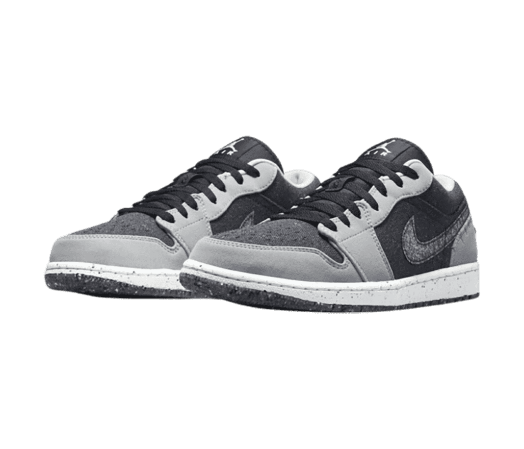 A pair of AJ1 Low “Crater” sneakers in charcoal fabric uppers with gray suede overlays and speckled soles.