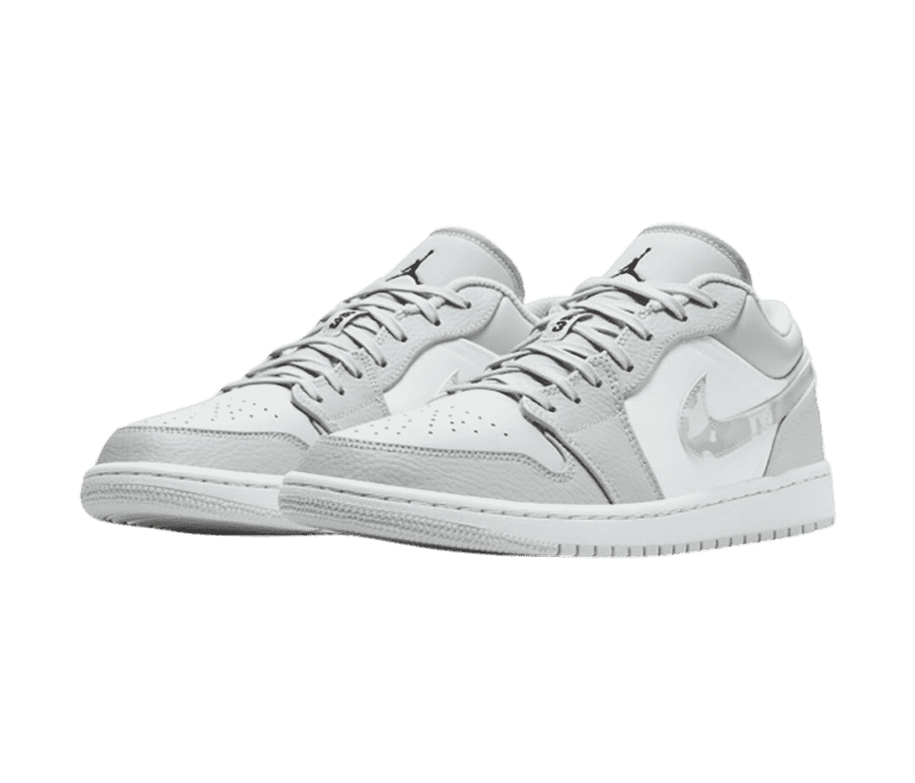 A pair of white and light gray AJ1 Low sneakers with black Jumpman logos on the tongues and camo patterned Swooshes.