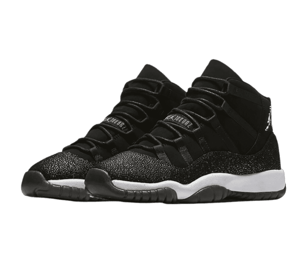 A black pair of AJ11 “Heiress” sneakers with white midsoles, stingray leather mudguards, and chrome Jumpman logos.