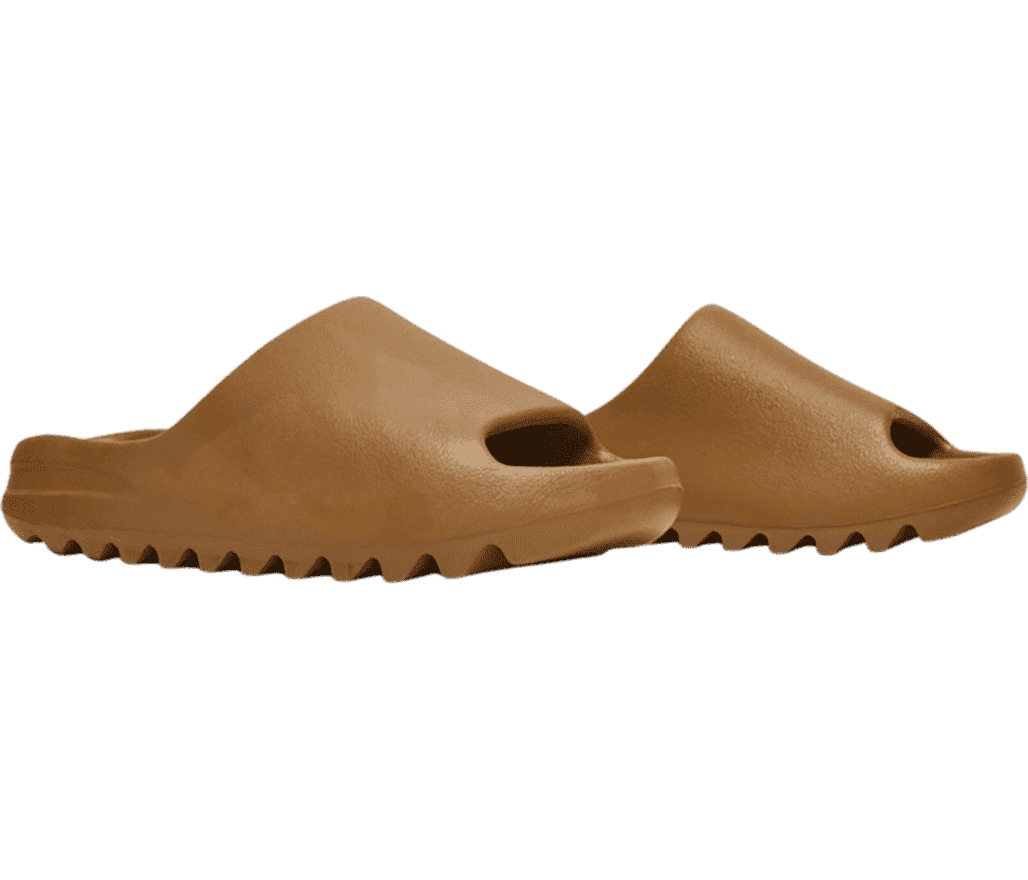 A pair of YEEZY slides in an ochre color made in a one-piece mold from EVA foam.
