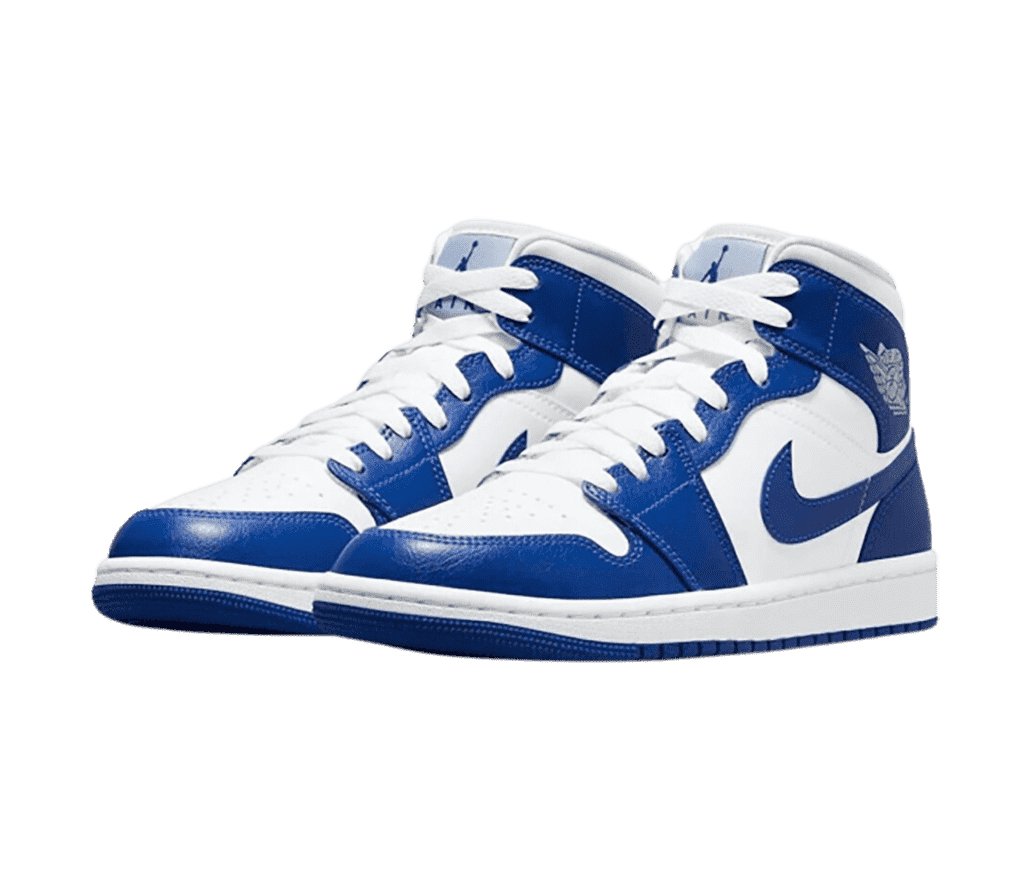 A white pair of AJ1 Mid sneakers with blue overlays and outsoles.