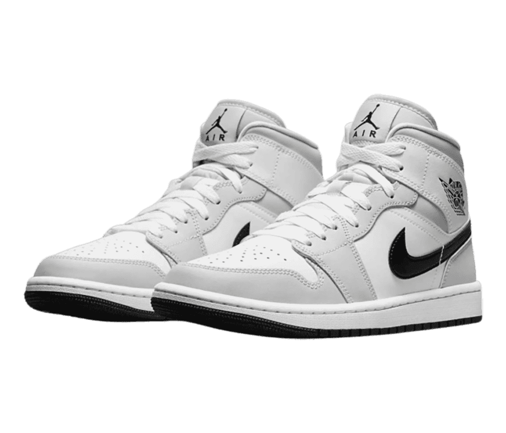 A pair of AJ1 Mid sneakers in gray and white with black Swooshes and outsoles.