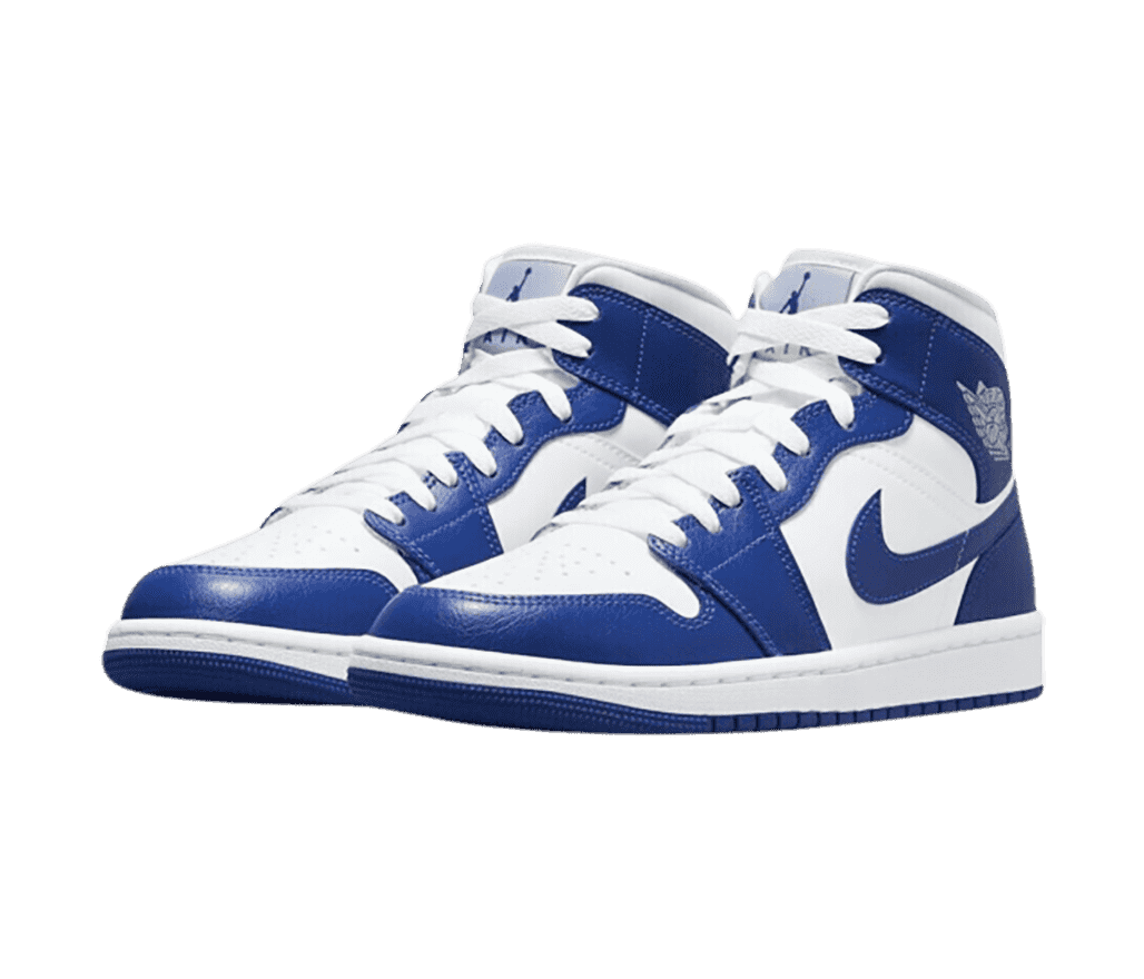 A white pair of AJ1 Mid sneakers with blue overlays and outsoles.
