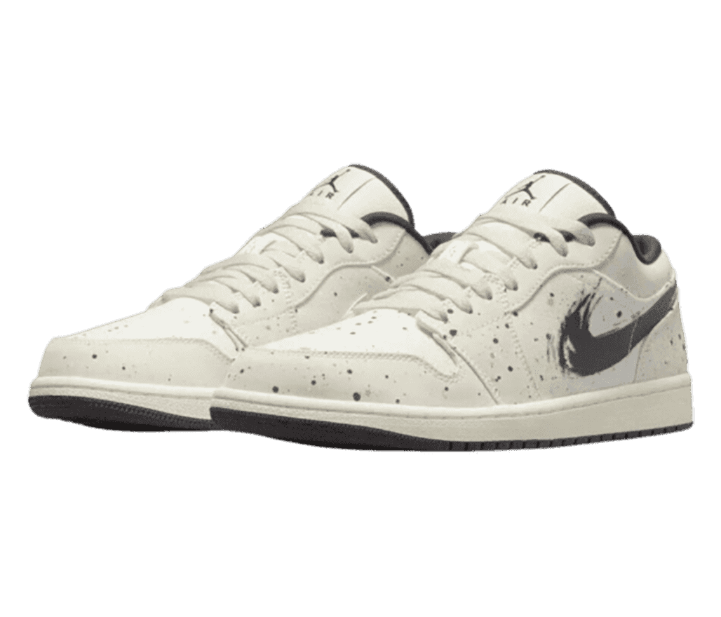 A pair of AJ1 Low sneakers in off-white uppers with dark gray paint speckles all over and brushstroked Swooshes.