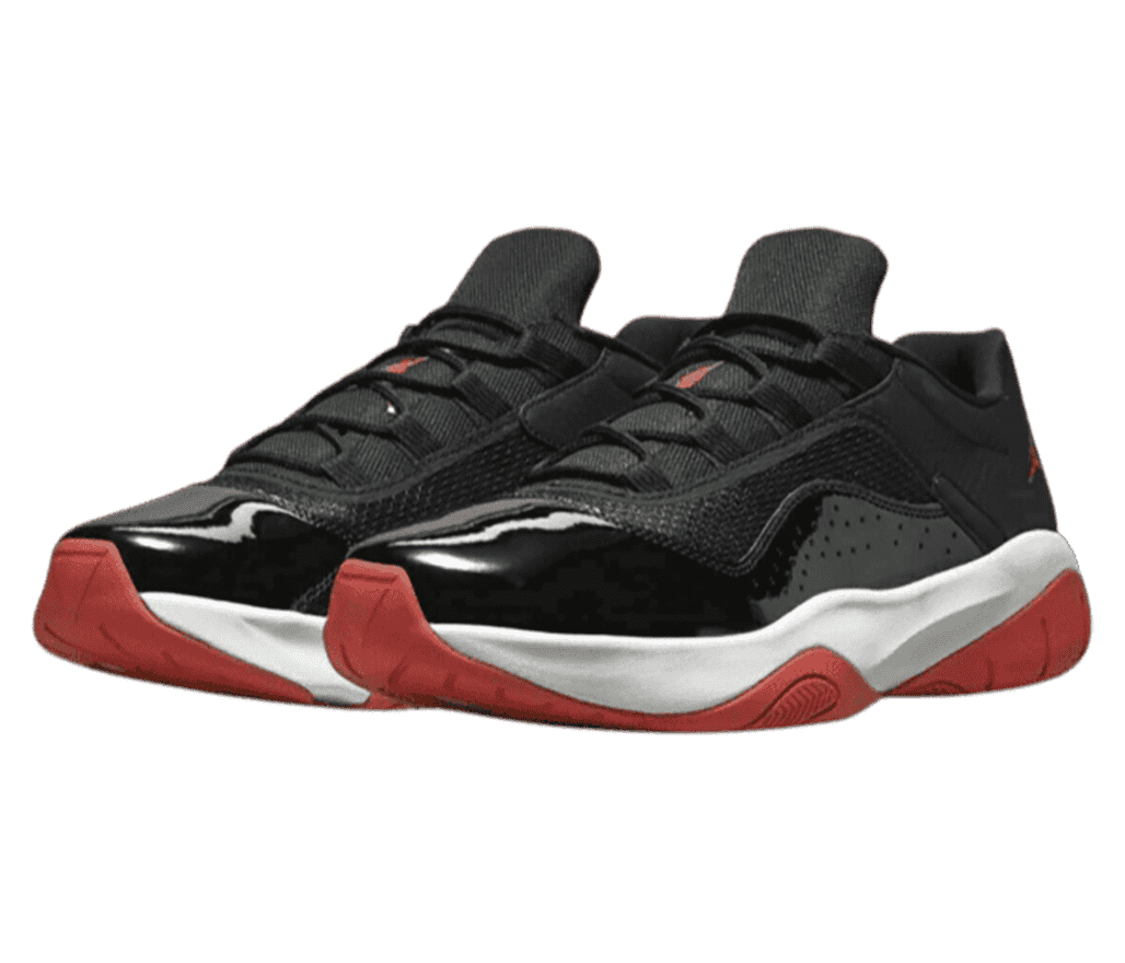 A black pair of AJ11 CMFT Low sneakers in leather, mesh, and patent leather, white midsoles, and red outsoles.