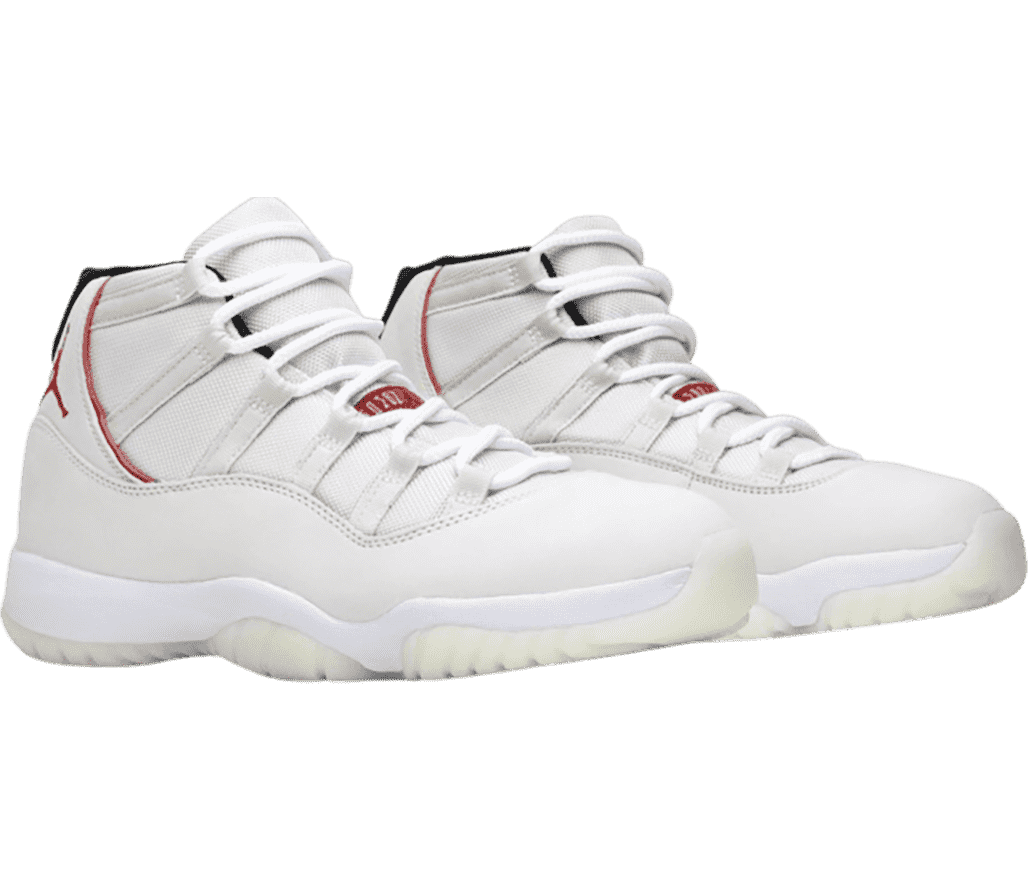 A white pair of AJ11 “Platinum Tint” sneakers with red details and off-white outsoles.
