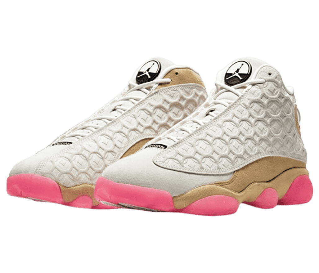 A pair of AJ13 “Chinese New Year” sneakers in gold suede and ivory uppers and pink details on the soles.