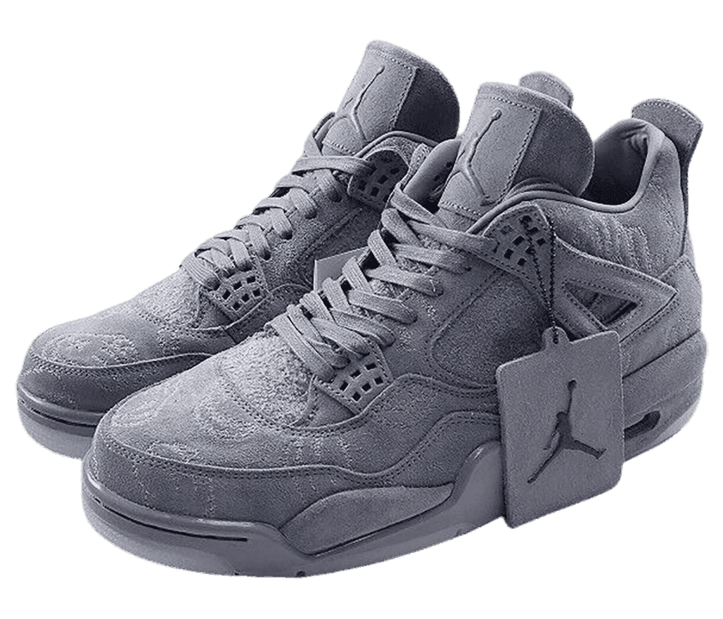 A gray suede pair of KAWS x AJ4 “Cool Grey” sneakers with subtle line art all over and a Jordan tag on the left shoe.