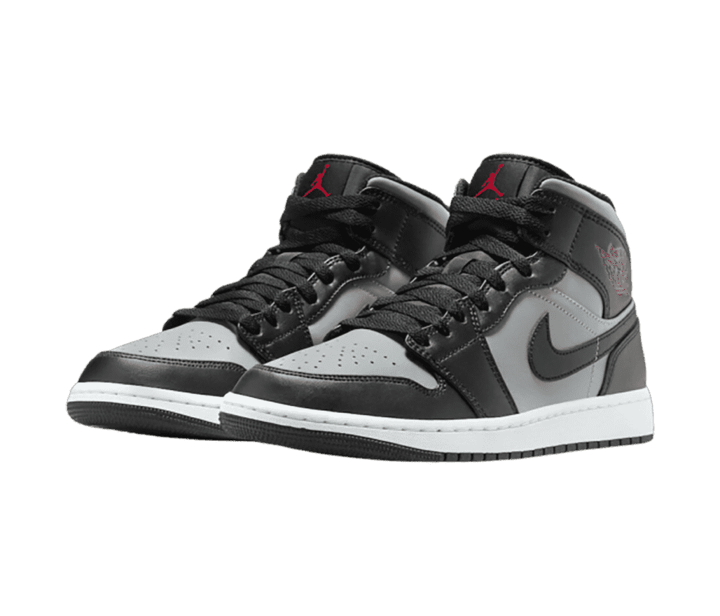 A pair of Nike 'Air Jordan 1' high-top sneakers that are gray and black with a few red accents to add dimension.