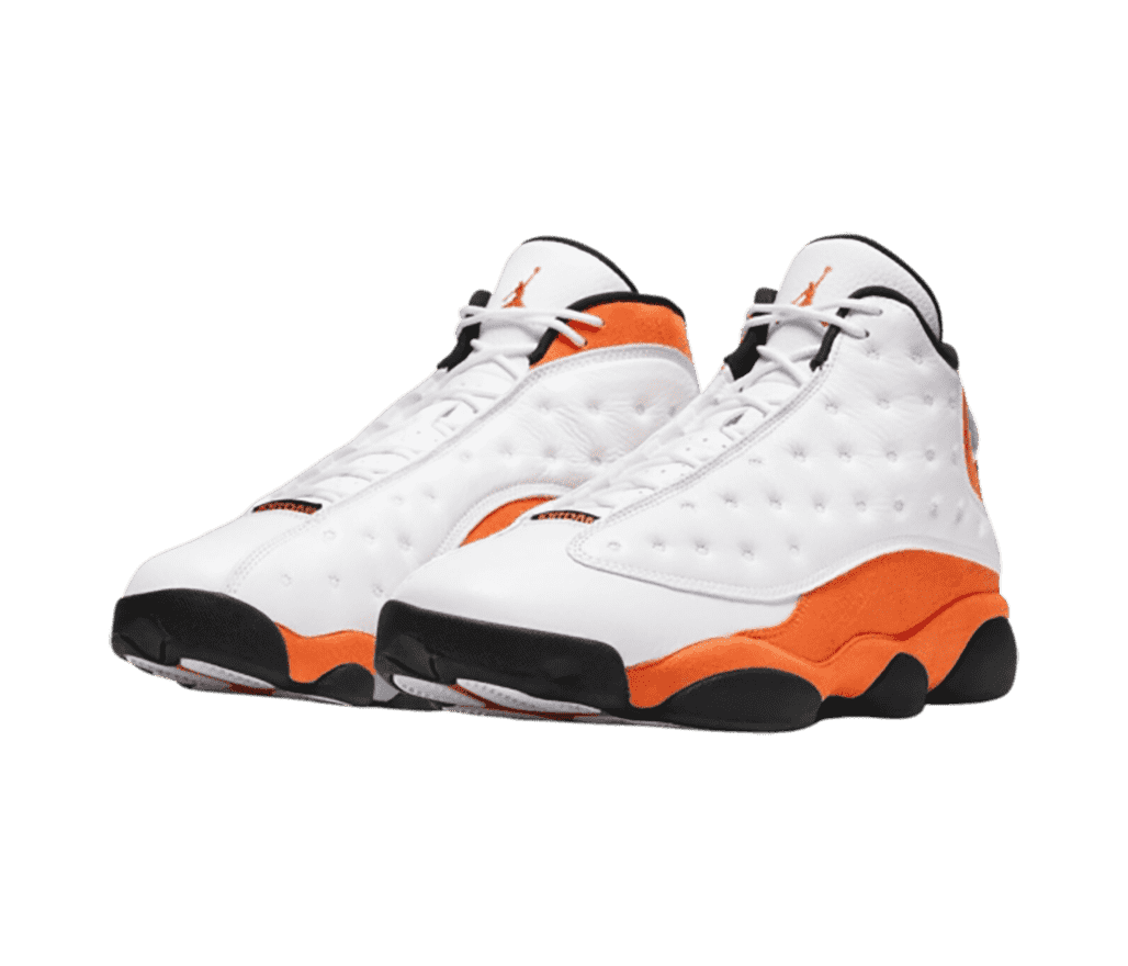 A white pair of AJ13 sneakers with orange suede quarters and collars and black outsoles.
