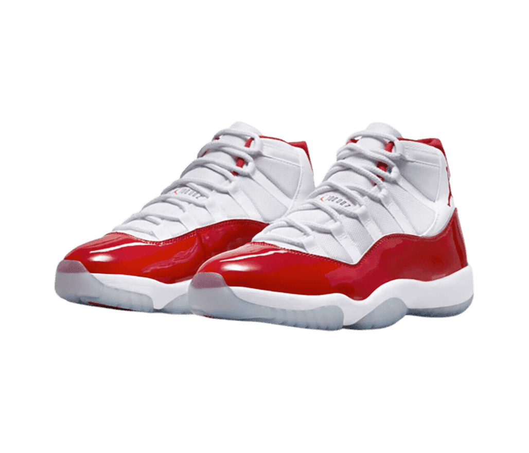 A white pair of AJ11 sneakers with red patent leather overlays and translucent outsoles.