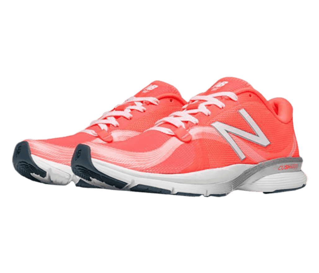 A pair of coral pink New Balance athletic shoes with white and gray accents along the sole.