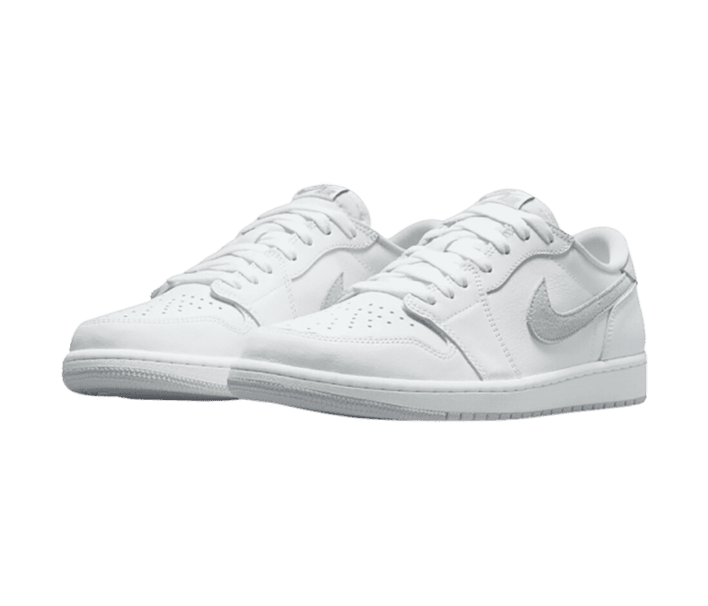 A white suede pair of AJ1 Low sneakers with gray Swooshes and outsoles.