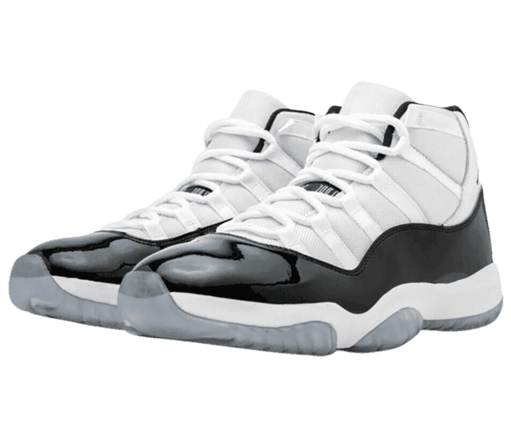 A white pair of AJ11 sneakers with black patent leather overlays and light gray translucent outsoles.