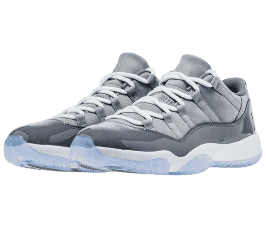 A gray pair of AJ11 Low sneakers with suede uppers, patent leather overlays, white midsoles, and blue translucent outsoles.