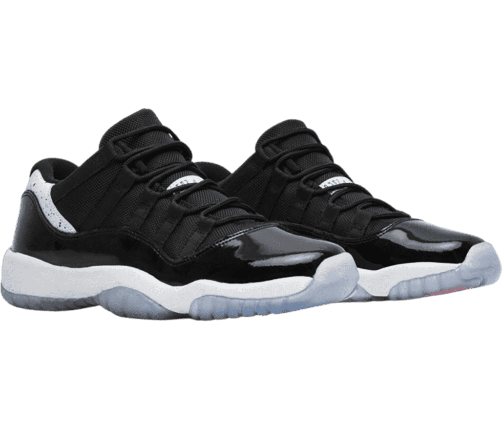 A black pair of AJ11 Low sneakers with white midsoles, translucent outsoles, and white accents with black speckles.